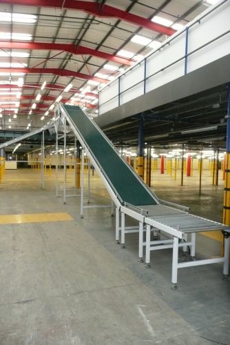 Large incline mezzanine floor conveyor with gravity roller in-feed. 