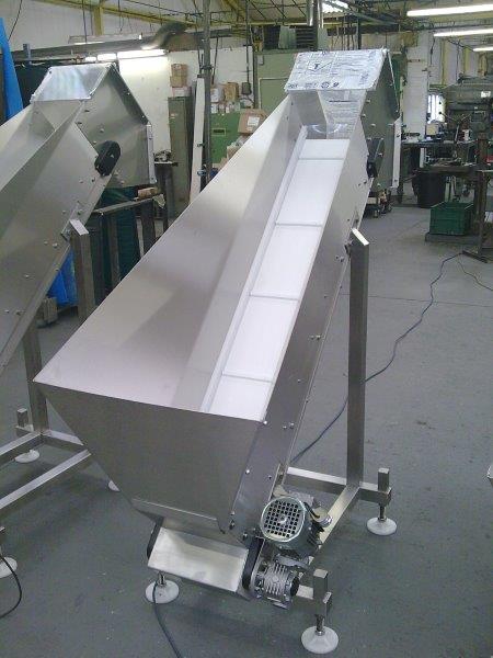 Elevating stainless steel belt conveyor with hopper.